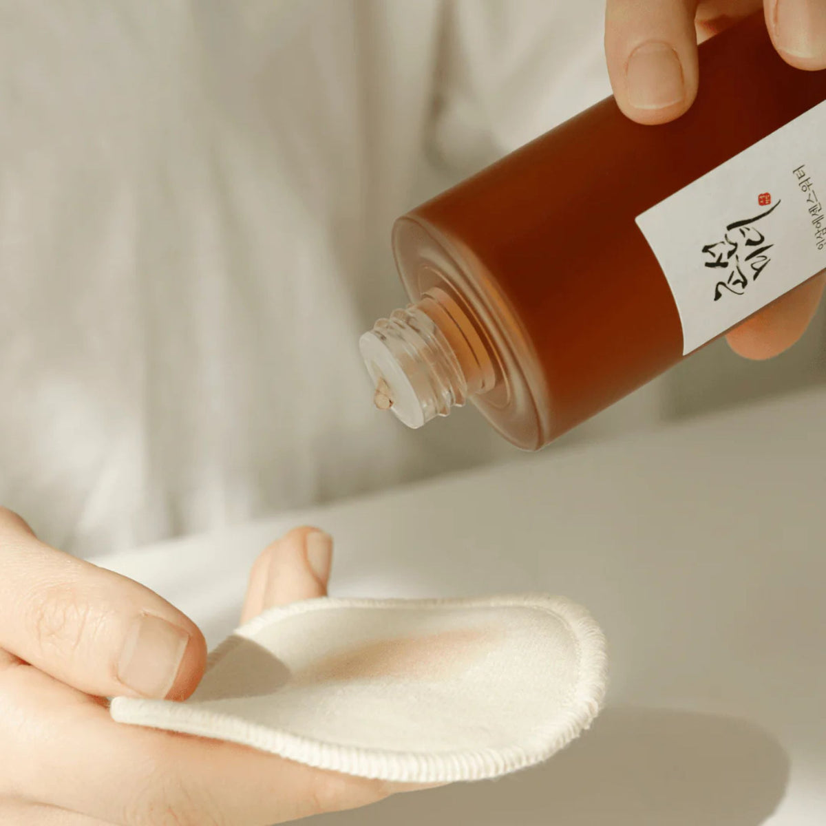Beauty of Joseon Ginseng Essence Water being poured onto cotton pad – gentle Korean skincare toner for daily use