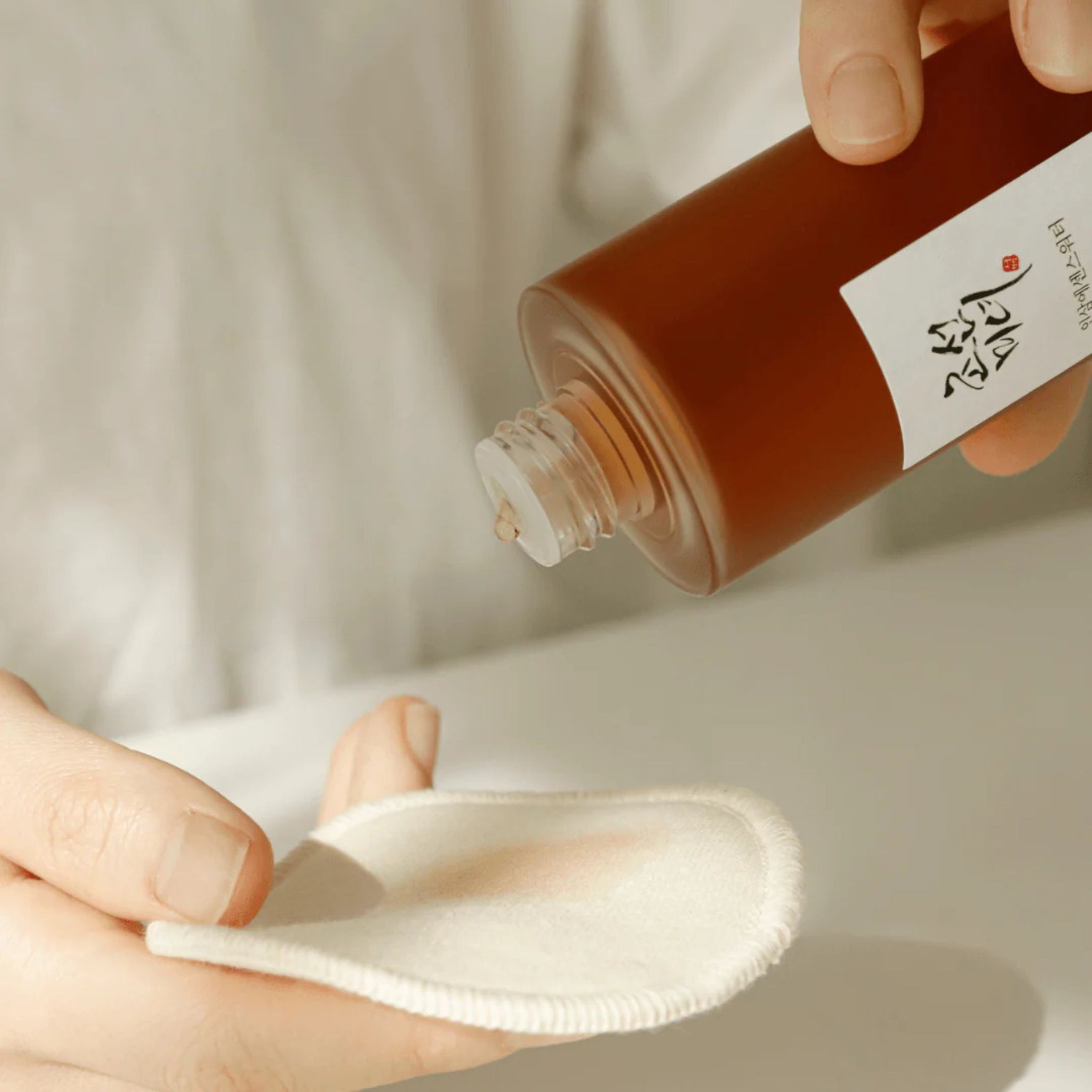 Beauty of Joseon Ginseng Essence Water being poured onto cotton pad – gentle Korean skincare toner for daily use