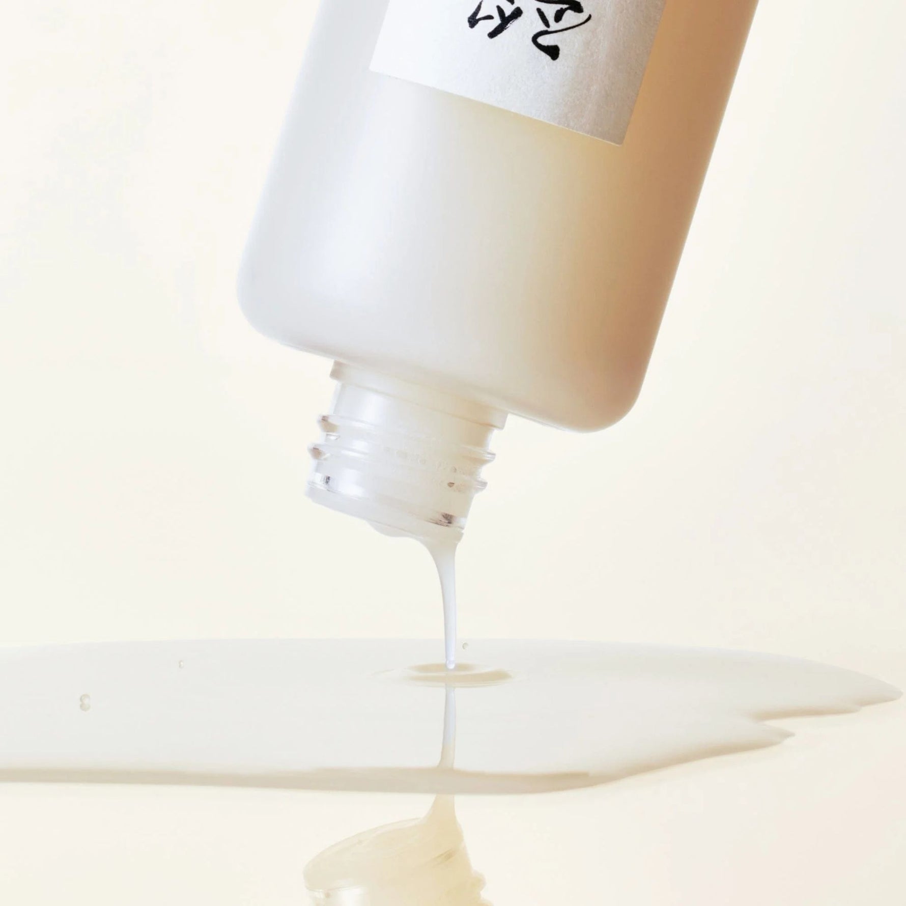Close-up of Beauty of Joseon Glow Replenishing Rice Milk Toner pouring, lightweight milky toner for brightening and moisturizing skin barrier care.