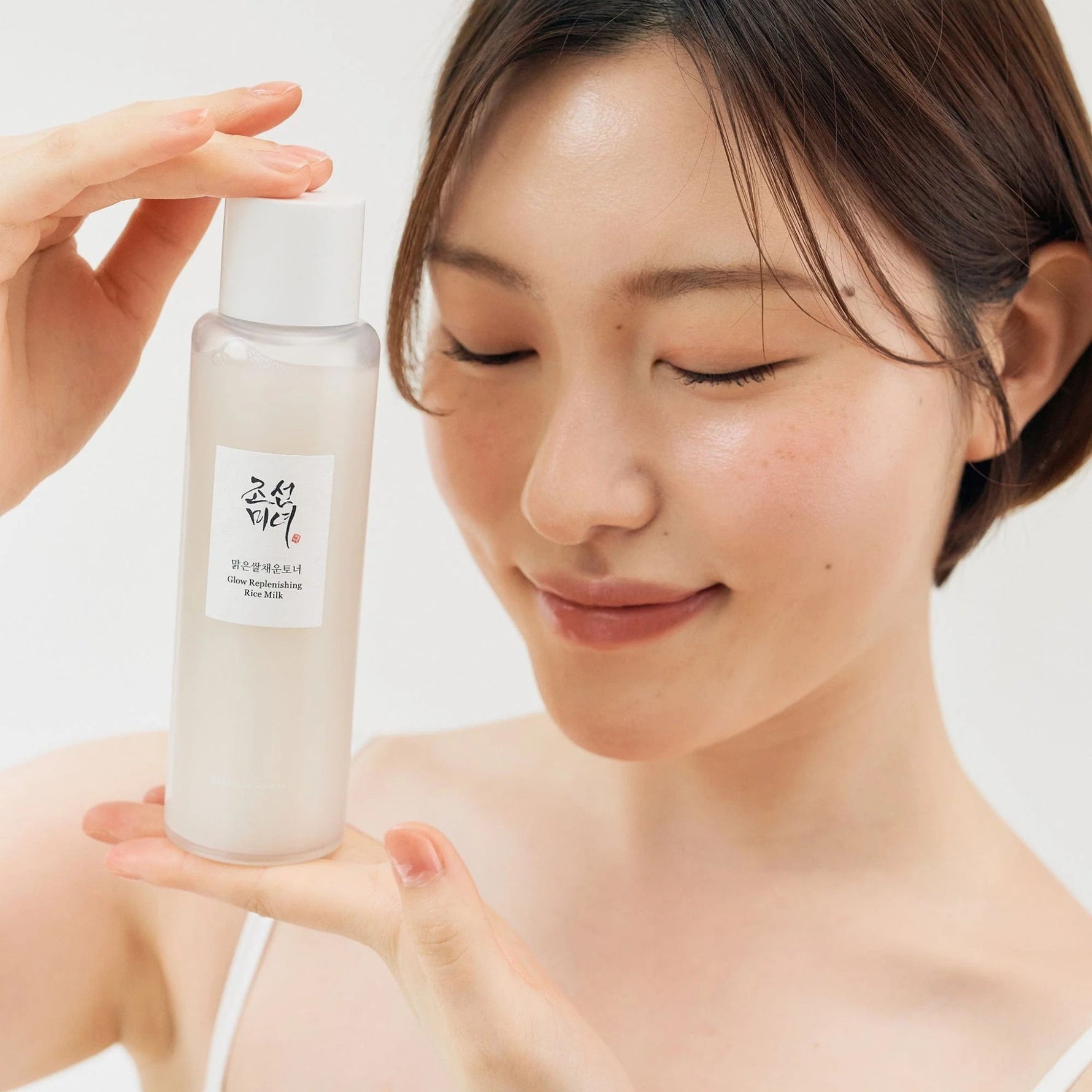 Model holding Beauty of Joseon Glow Replenishing Rice Milk Toner, Korean skincare toner for glowing, hydrated, and smooth complexion.