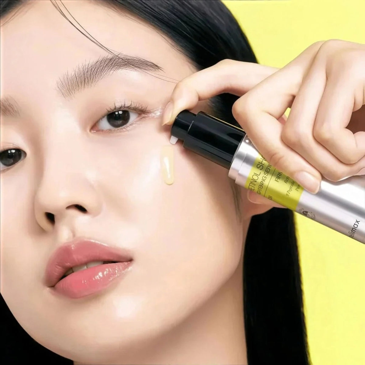 Woman applying Celimax Vita-A Retinol Shot Tightening Serum to her cheek with the pump bottle - K-beauty firming serum
