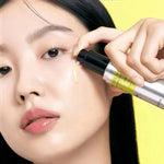 Woman applying Celimax Vita-A Retinol Shot Tightening Serum to her cheek with the pump bottle - K-beauty firming serum