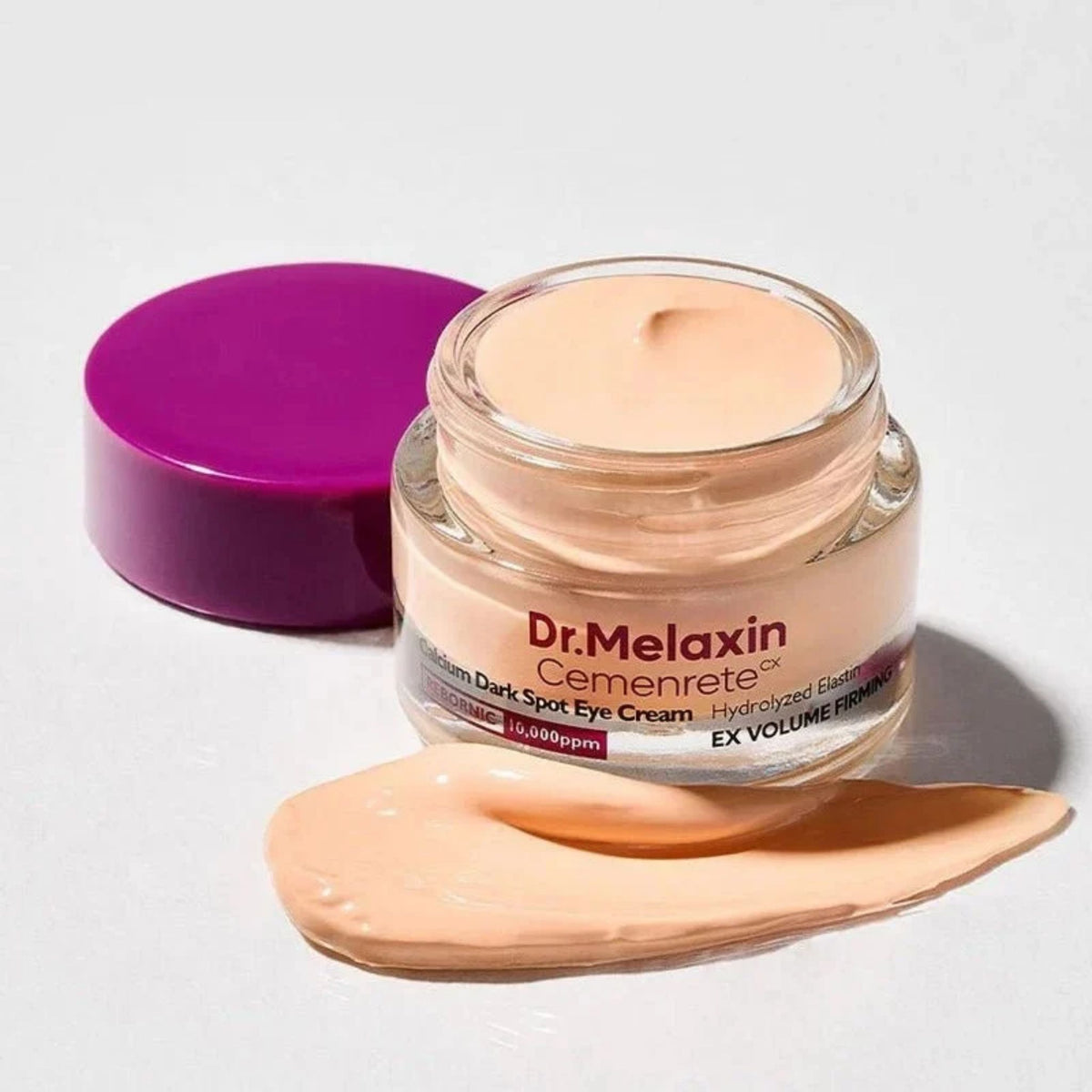 Dr.Melaxin Cemenrete Calcium Dark Spot Eye Cream open jar with peach cream swatch – firming, brightening eye cream texture