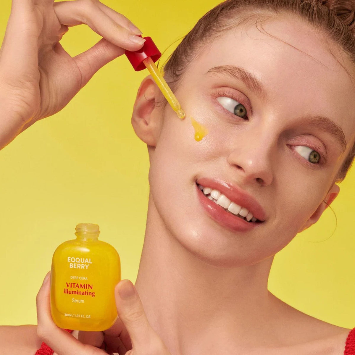 Model applying Eqqualberry Vitamin Illuminating Serum with dropper for brightening, glowing, even-toned skin