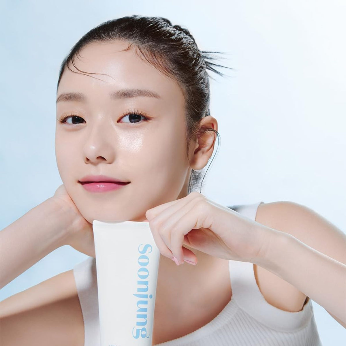 Smiling woman holding Etude Soon Jung Foam Cleanser – gentle low-pH cleanser for soft, healthy-looking skin