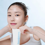 Smiling woman holding Etude Soon Jung Foam Cleanser – gentle low-pH cleanser for soft, healthy-looking skin