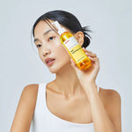 Model holding Manyo Pure Cleansing Oil – nourishing Korean cleansing oil that removes makeup and impurities