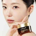 Model with glowing skin holding Medicube Deep Vita C Capsule Cream – K-beauty vitamin C cream for radiant, dewy skin