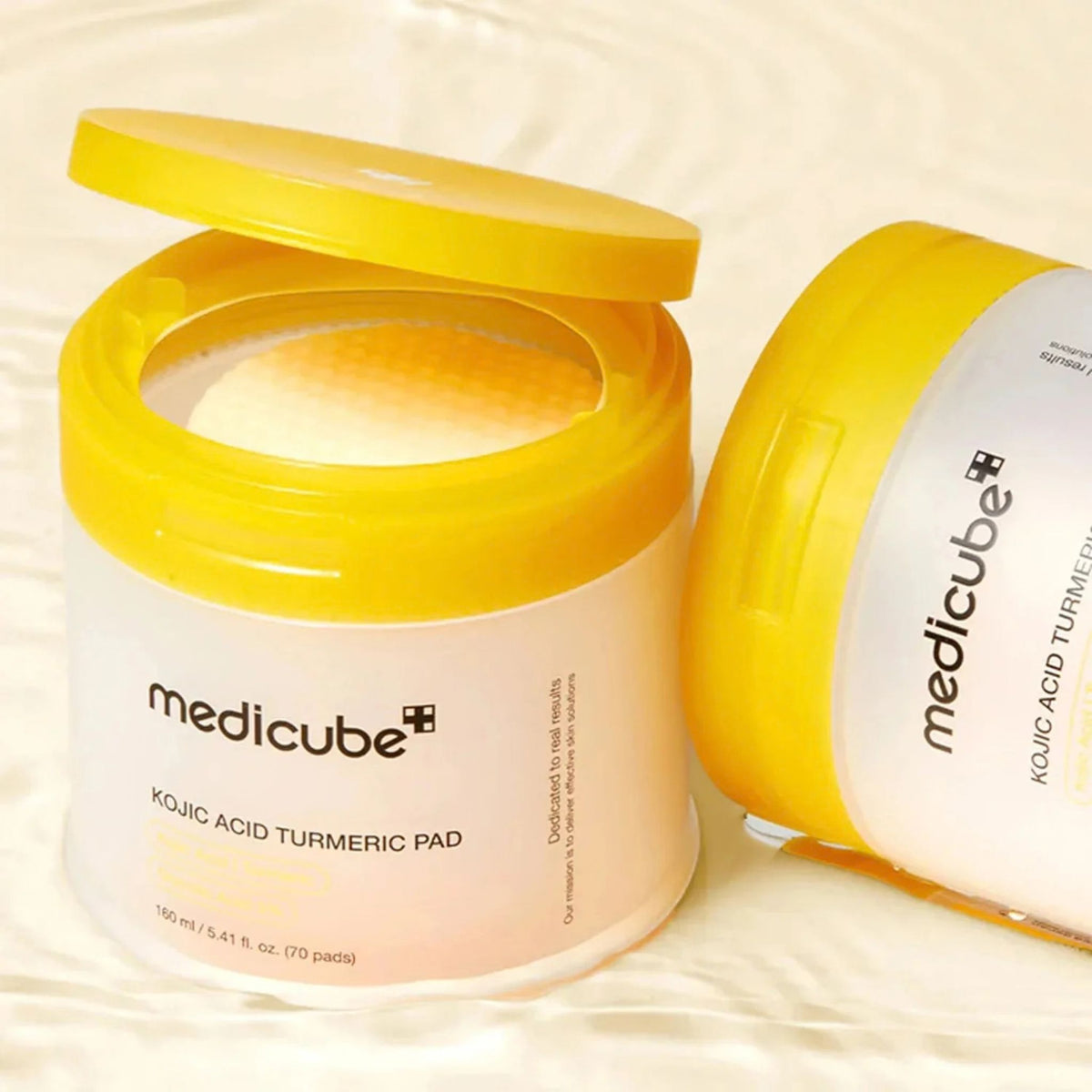 Open jar of Medicube Kojic Acid Turmeric Pad with 70 pre-soaked toner pads inside next to a second jar