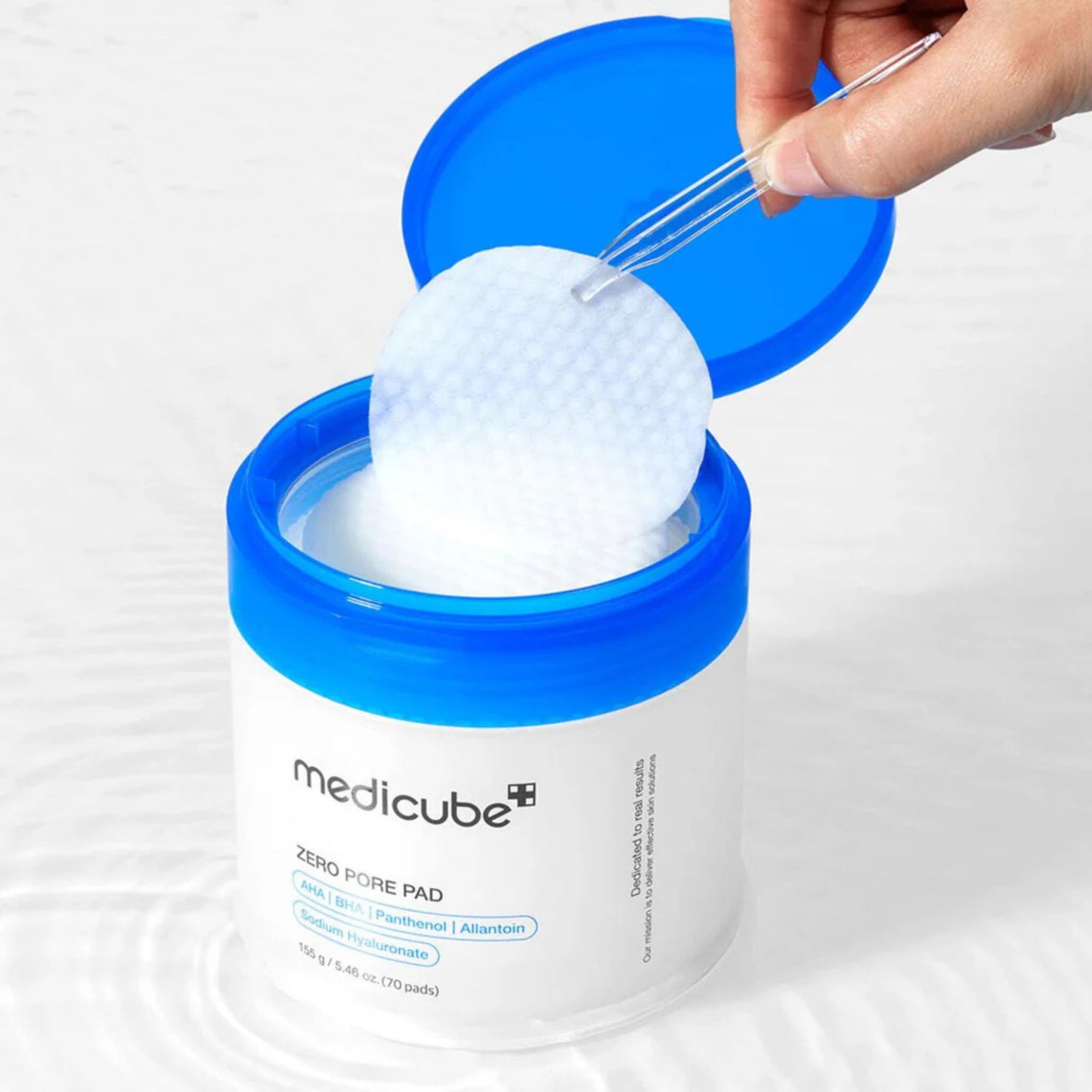 Medicube pore tightening toner pad being lifted from jar Korean skincare exfoliating pads