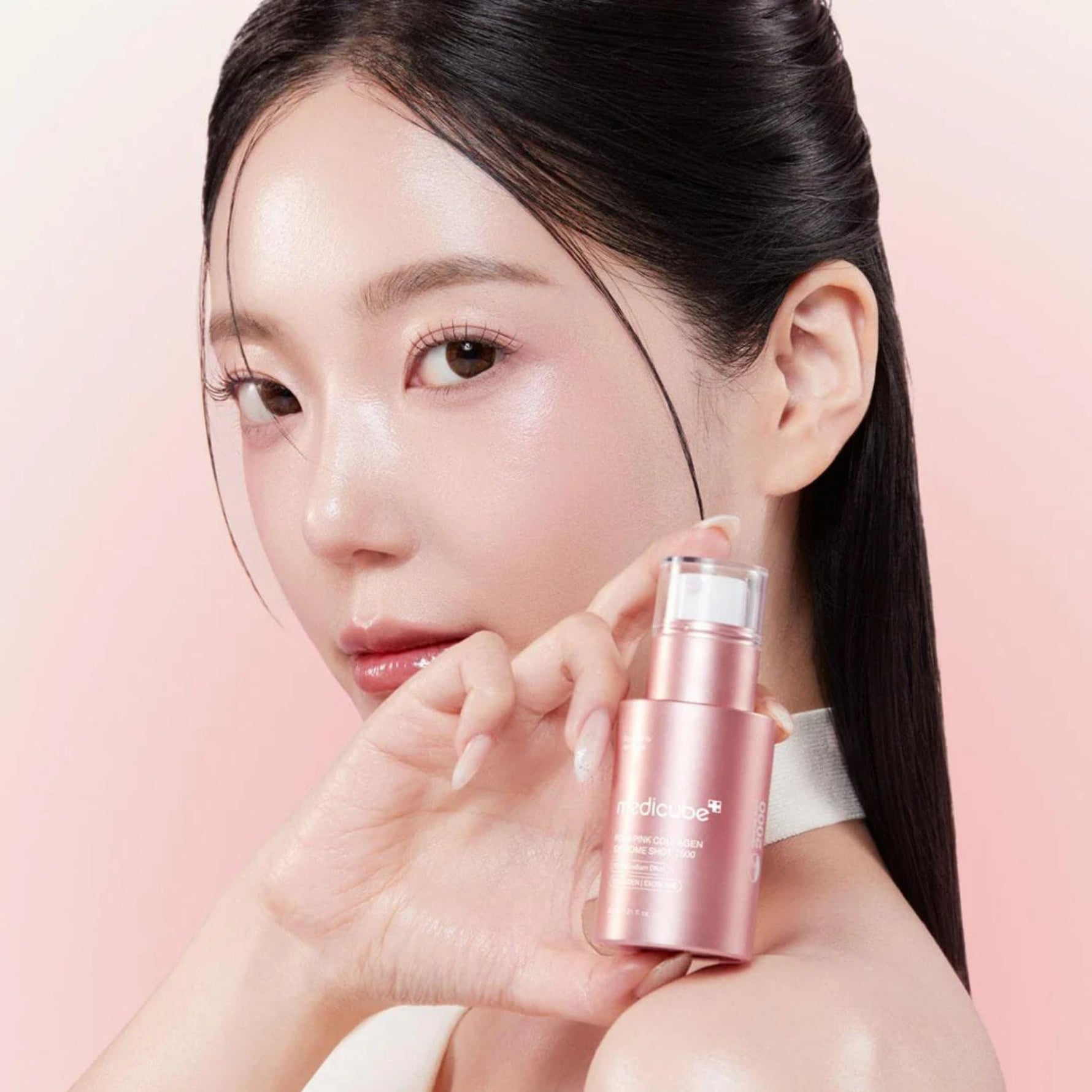 Model holding Medicube PDRN Pink Collagen Exosome Shot 7500 serum showcasing radiant hydrated and youthful-looking skin