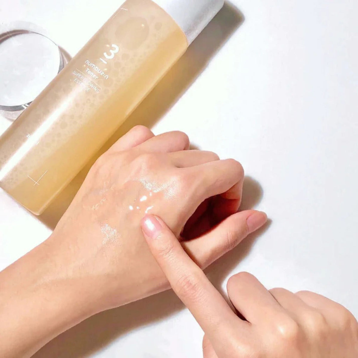 Numbuzin No.3 Super Glowing Essence Toner – watery, essence-like texture applied on hand for radiant hydration