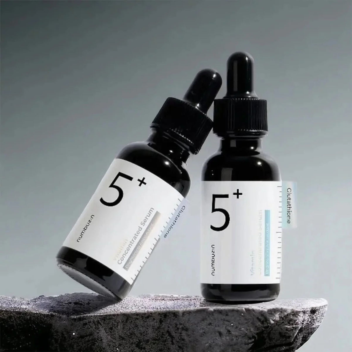 Two numbuzin No.5+ Glutathione Vitamin Concentrated Serum bottles on dark stone – Korean brightening serum for even skin tone
