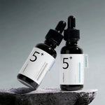 Two numbuzin No.5+ Glutathione Vitamin Concentrated Serum bottles on dark stone – Korean brightening serum for even skin tone