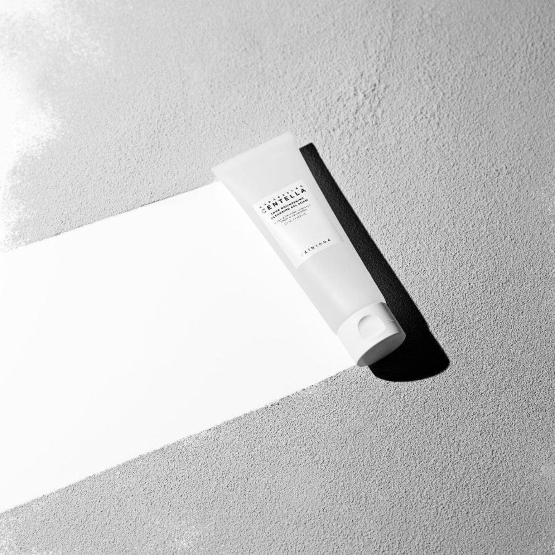 Skin1004 Tone Brightening Cleansing Gel Foam 125ml – Korean facial cleanser for brightening and soothing, product photo on textured background