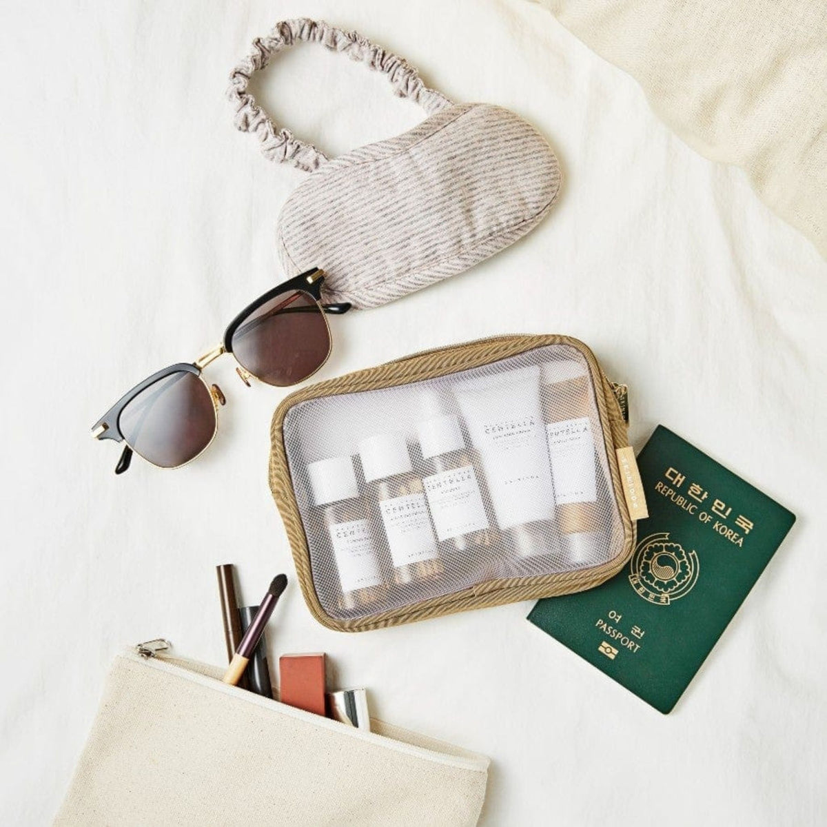 Skin1004 Madagascar Centella Travel Kit neatly packed inside transparent travel pouch with sunglasses and passport